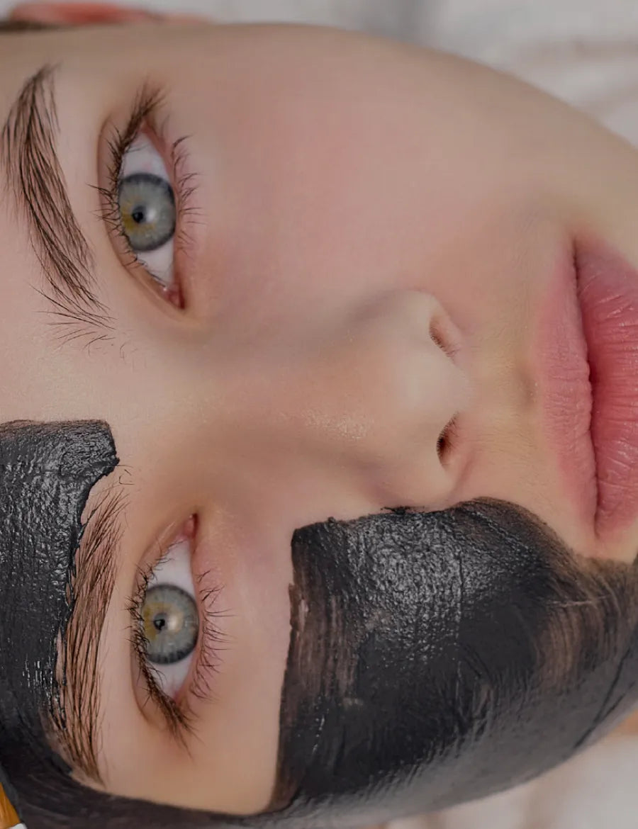 Close-up of a person wearing a black facial mask on their face.