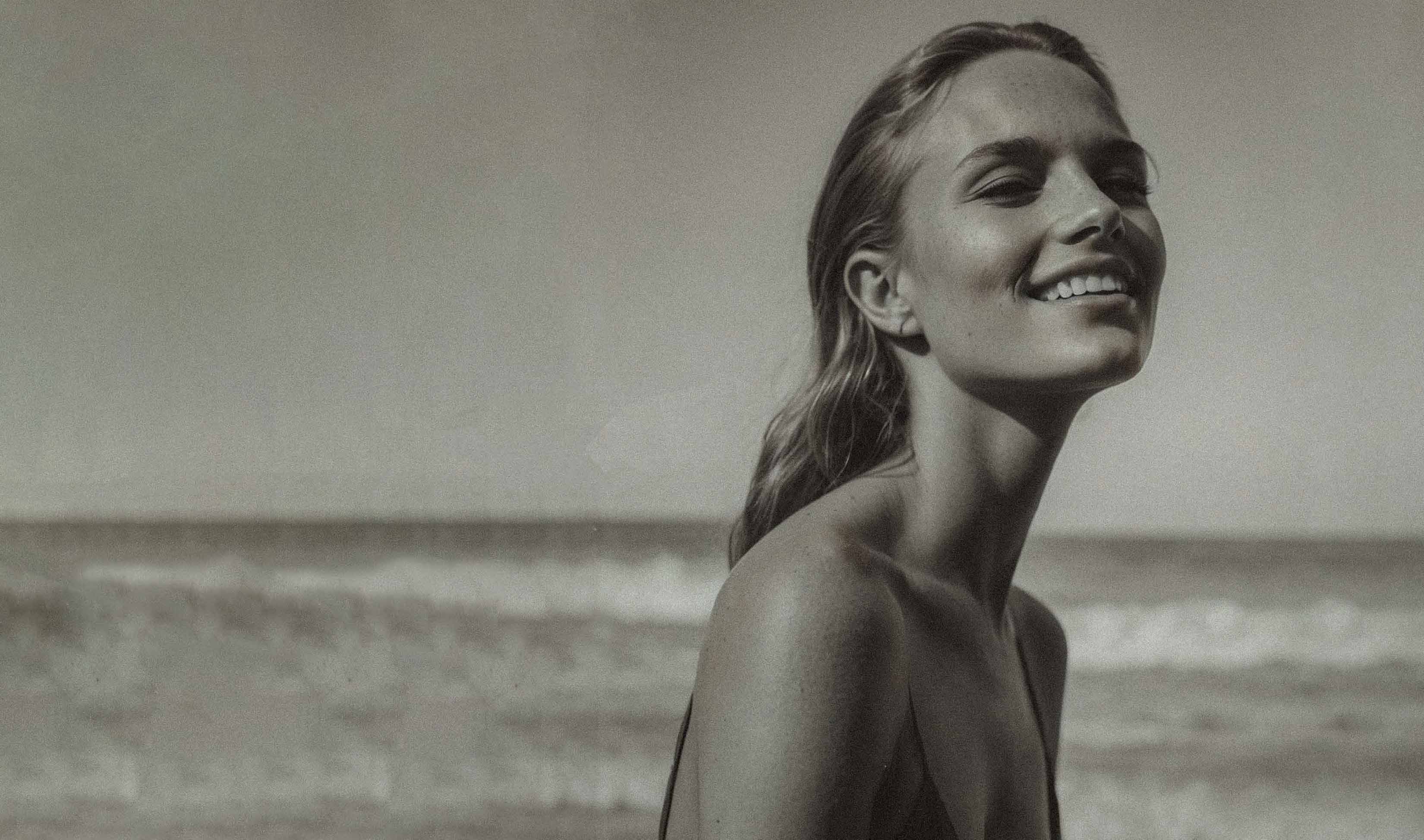Black and white photo of a woman on a beach